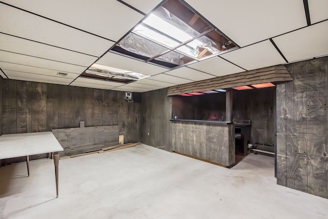 basement featuring wood walls