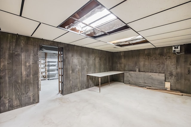 basement featuring wooden walls