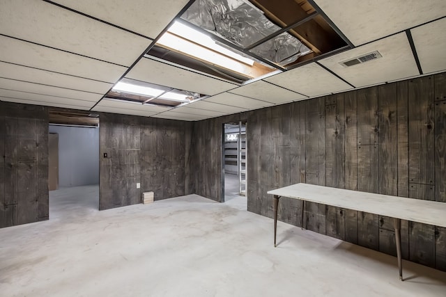 basement featuring wood walls