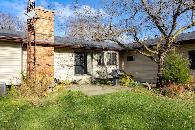 rear view of property with a yard