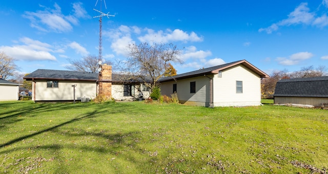 rear view of house featuring a lawn