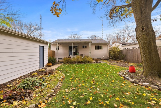 back of house with fence and a yard