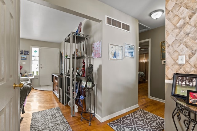 entryway featuring wood finished floors, visible vents, and baseboards