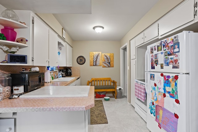 kitchen featuring white appliances, a sink, white cabinetry, light countertops, and open shelves