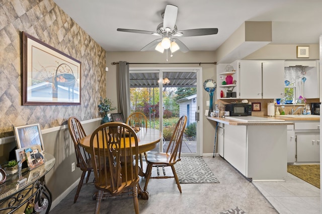 tiled dining area featuring ceiling fan and sink