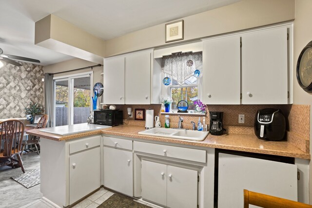 kitchen featuring sink, ceiling fan, decorative backsplash, light tile patterned flooring, and white cabinetry