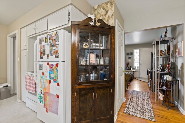 bar featuring white appliances and light wood-style flooring