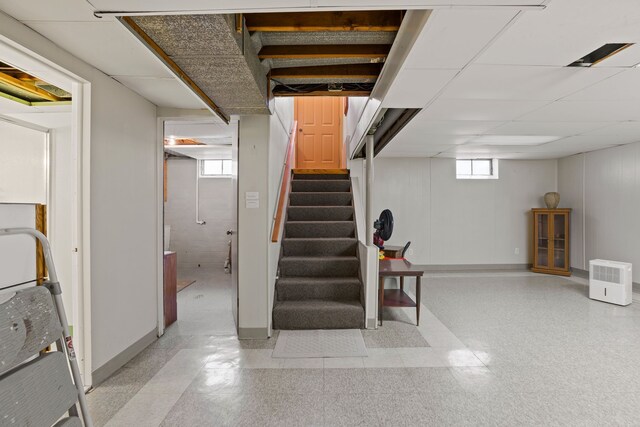 basement featuring a paneled ceiling and plenty of natural light