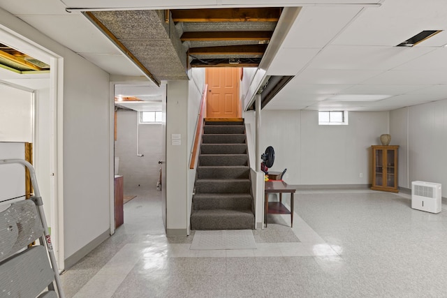 basement with baseboards and stairs