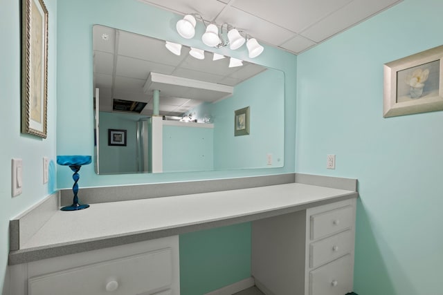 bathroom with a drop ceiling and vanity