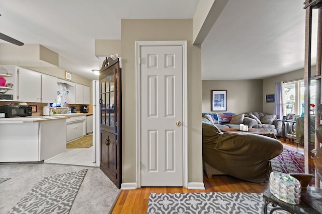 kitchen with black microwave, white cabinetry, light countertops, dishwasher, and open shelves