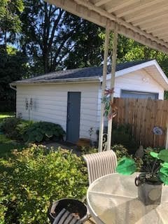 view of outbuilding with an outbuilding, outdoor dining space, and fence