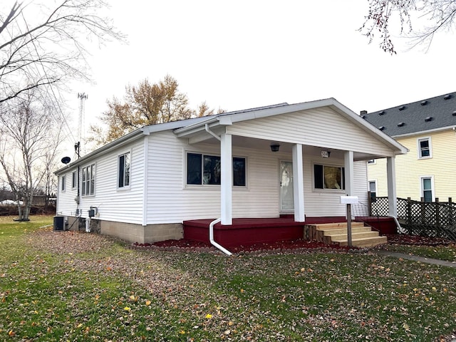 manufactured / mobile home featuring cooling unit, a porch, and a front lawn