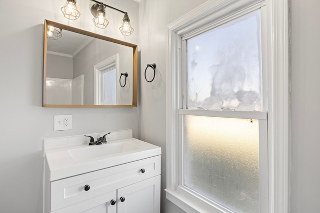 bathroom featuring vanity, a healthy amount of sunlight, and crown molding