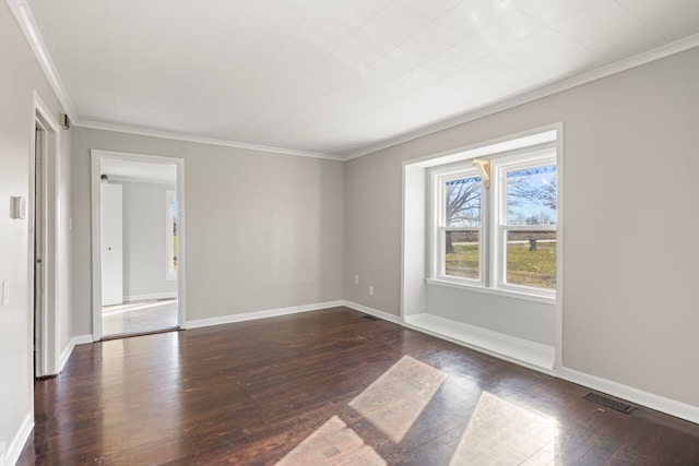 spare room featuring dark hardwood / wood-style flooring and crown molding