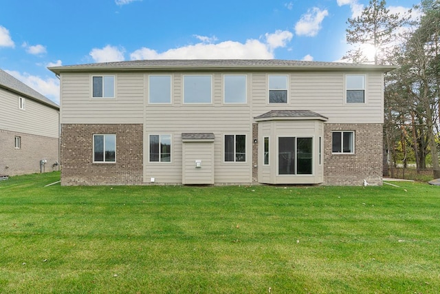 rear view of house featuring a lawn