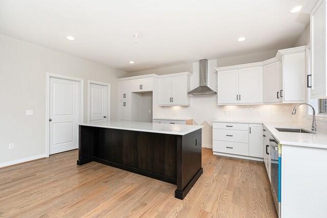 1685 E Wattles Rd, Troy, MI 48085 - kitchen featuring wall chimney range hood, a sink, light wood-style floors, white cabinetry, and recessed lighting