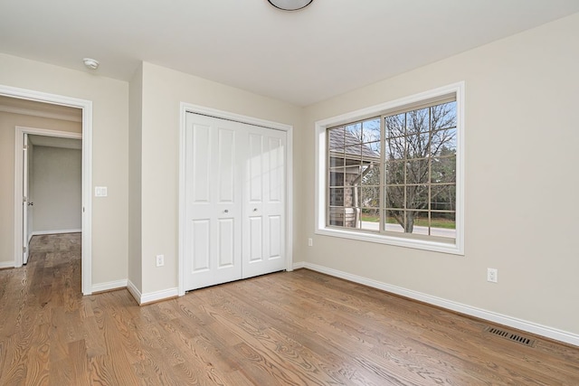 unfurnished bedroom featuring a closet and light hardwood / wood-style floors