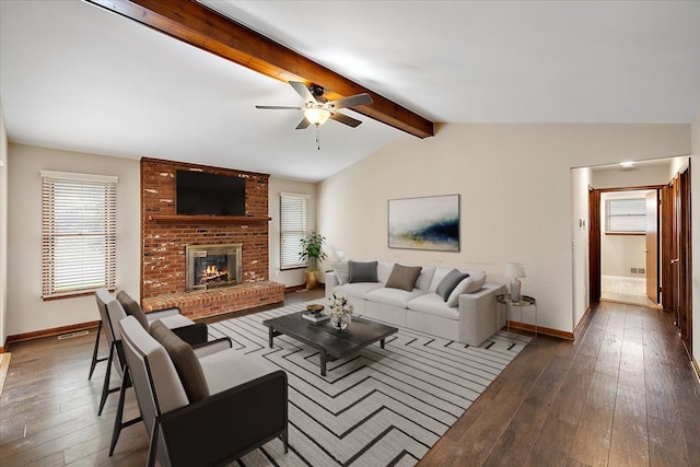 living room with vaulted ceiling with beams, dark hardwood / wood-style floors, ceiling fan, and a fireplace