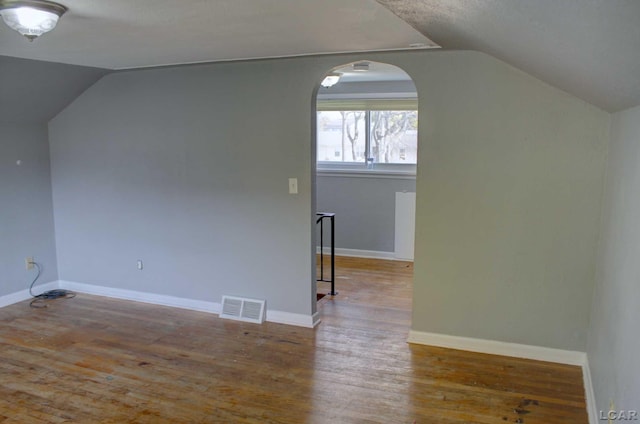 bonus room with wood-type flooring and vaulted ceiling