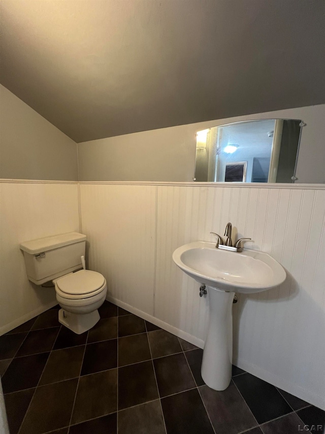 bathroom featuring tile patterned flooring, lofted ceiling, and toilet