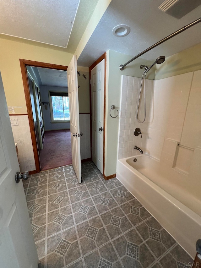 bathroom with tile patterned floors, a textured ceiling, and tub / shower combination