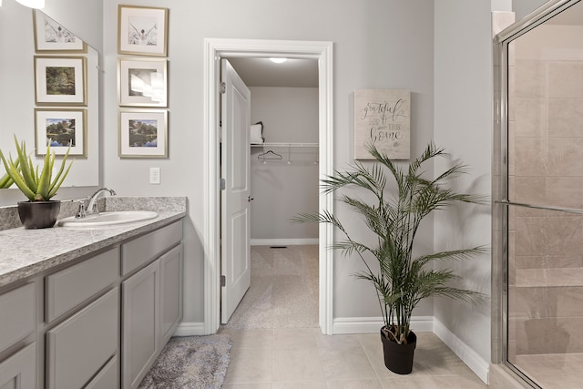 bathroom with tile patterned flooring, vanity, and a shower with door