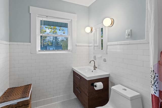 bathroom with a shower with shower curtain, vanity, toilet, and tile walls