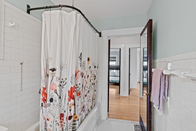 bathroom with tile patterned floors, shower / tub combo with curtain, and tile walls