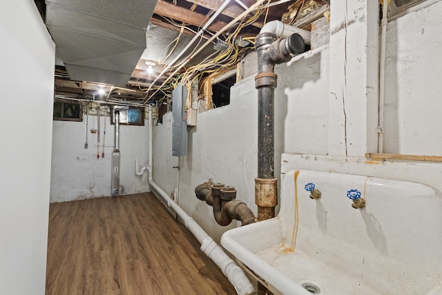 basement with hardwood / wood-style floors and electric panel