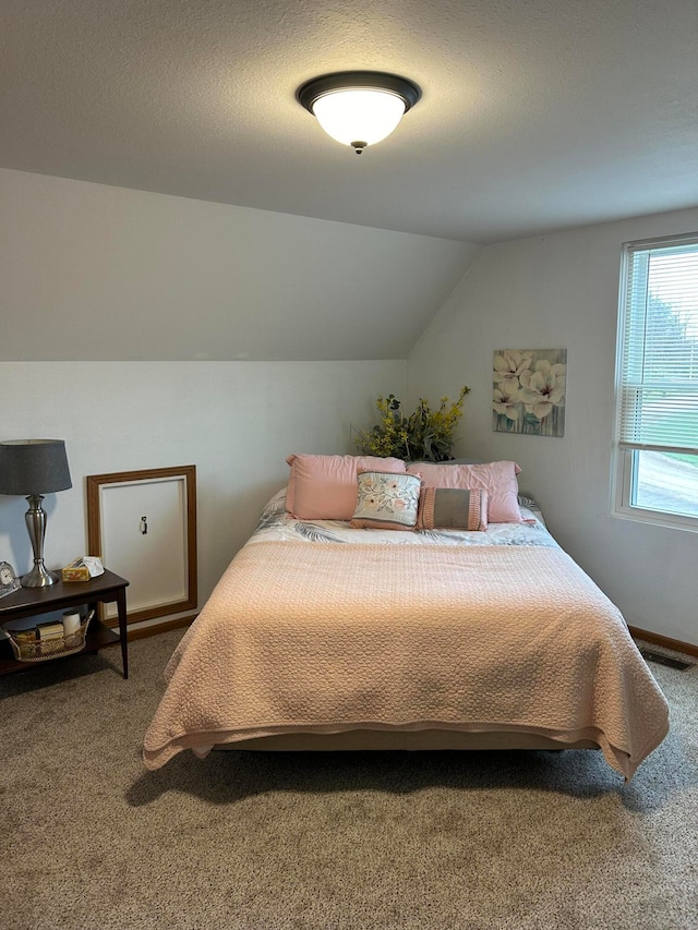 carpeted bedroom with lofted ceiling and a textured ceiling