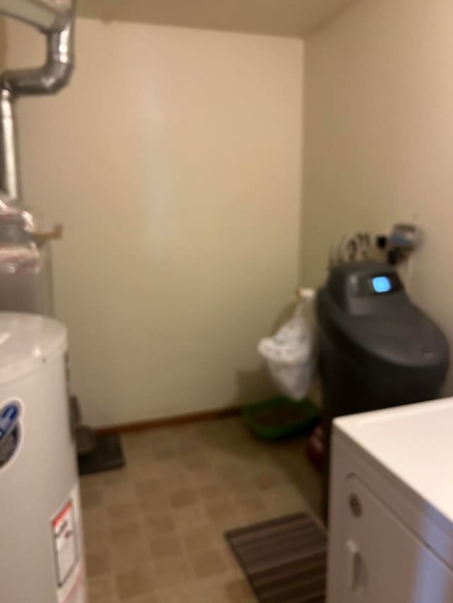 clothes washing area with water heater and washer / dryer