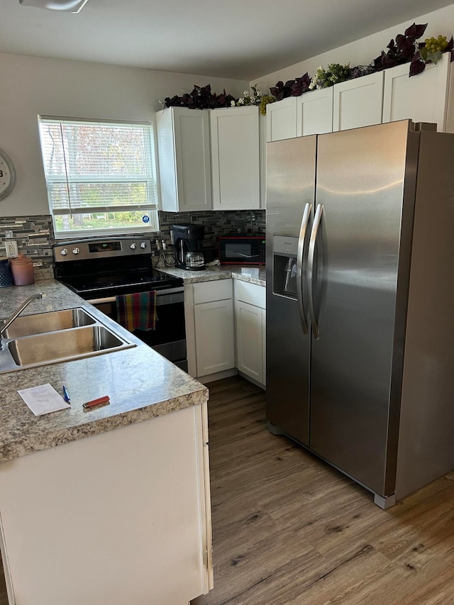 kitchen with decorative backsplash, stainless steel appliances, white cabinetry, and sink