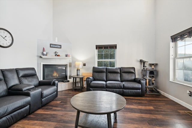 living room with dark hardwood / wood-style flooring and a towering ceiling