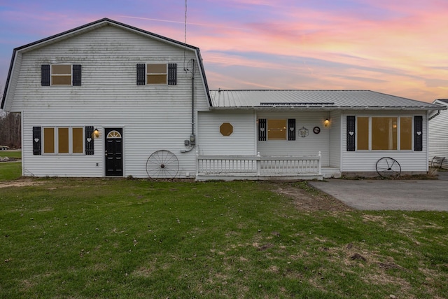 view of front of property featuring a yard, a patio, and covered porch