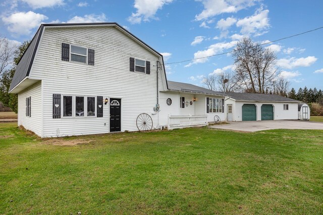 5085 W Redstone Rd, Michigan, MI 48880 - rear view of property with a garage, an outdoor structure, a yard, and driveway
