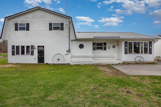 view of front of property with a front yard, a patio, and covered porch