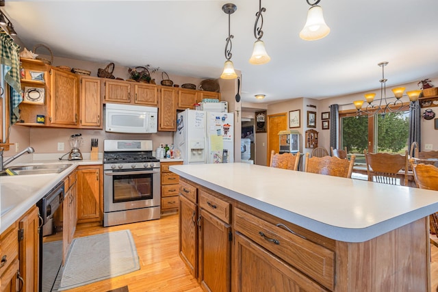 kitchen with sink, a kitchen island, pendant lighting, white appliances, and light hardwood / wood-style floors