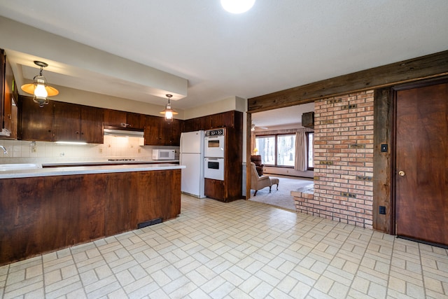 kitchen with kitchen peninsula, decorative backsplash, white appliances, dark brown cabinetry, and hanging light fixtures