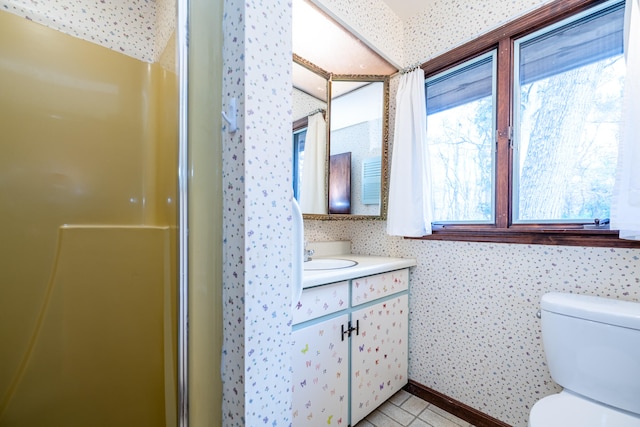 bathroom with walk in shower, vanity, and toilet