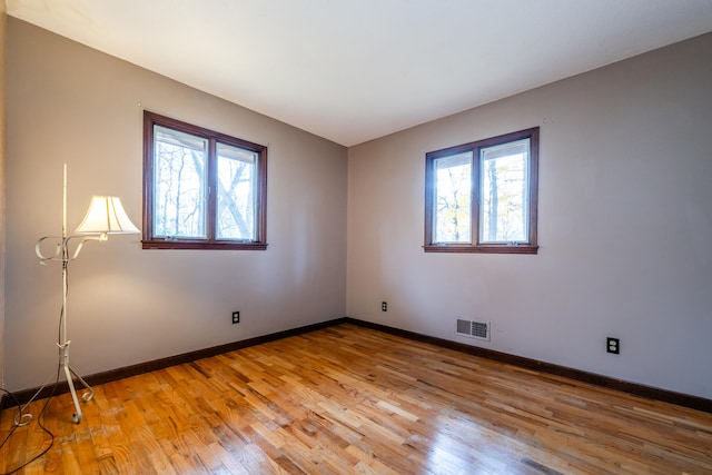 unfurnished room featuring a healthy amount of sunlight and light hardwood / wood-style flooring