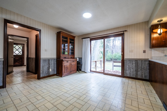 unfurnished dining area featuring wooden walls