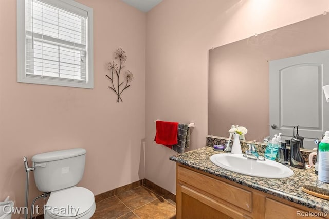 bathroom with tile patterned flooring, vanity, and toilet