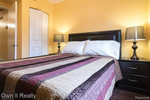 bedroom featuring dark hardwood / wood-style flooring and a closet