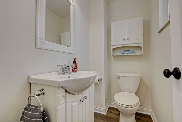 bathroom featuring toilet, vanity, and hardwood / wood-style flooring