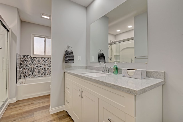 bathroom with a bathing tub, hardwood / wood-style floors, and vanity