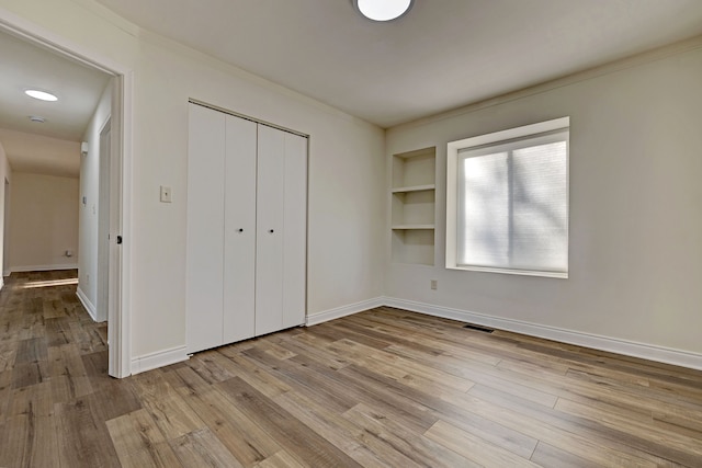 unfurnished bedroom with a closet and light hardwood / wood-style flooring