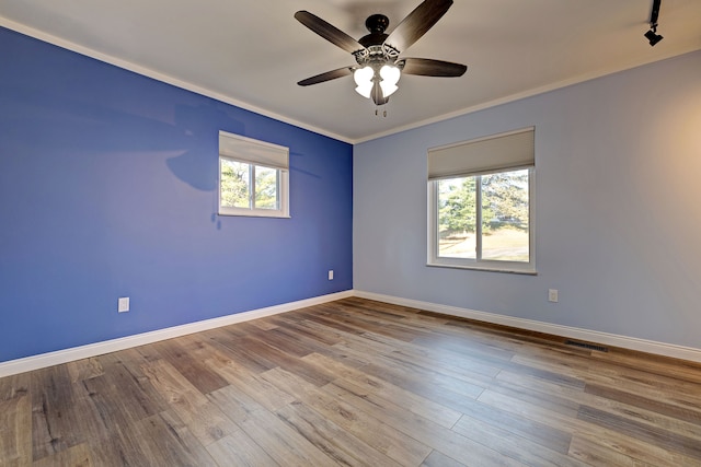 spare room featuring plenty of natural light, ceiling fan, ornamental molding, and light hardwood / wood-style flooring