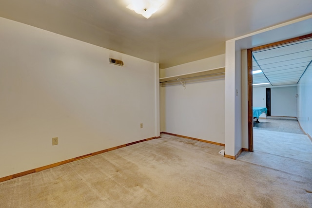 unfurnished bedroom featuring light carpet and a closet