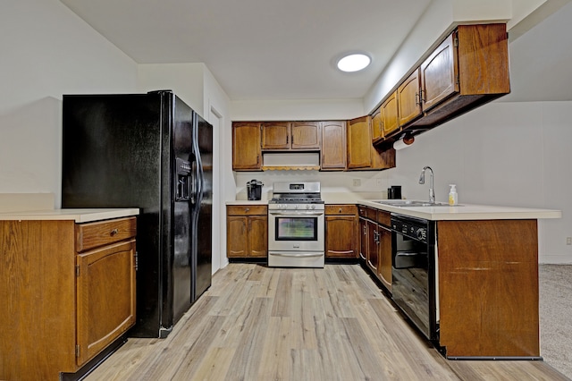 kitchen with kitchen peninsula, sink, black appliances, and light hardwood / wood-style flooring